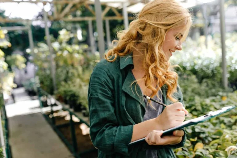 Agricultural consultant taking notes on a clipboard in a nursery